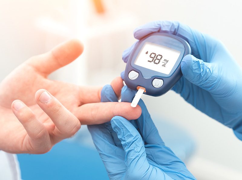 Doctor checking blood sugar level with glucometer